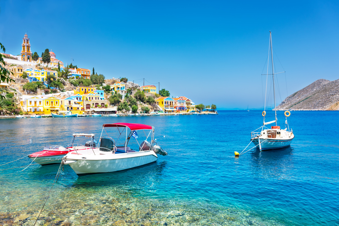 Anchored boats and colorful neoclassical houses in bay of Symi (Symi Island, Greece)